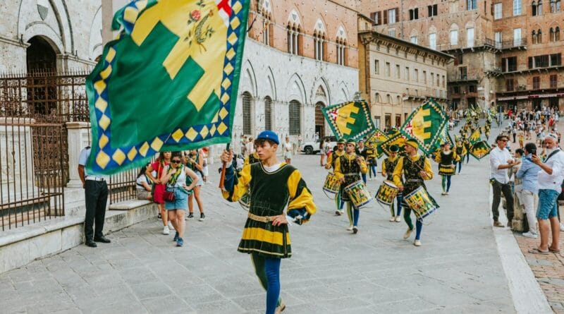 Des porte-drapeaux traditionnels lors d'un défilé haut en couleur sur la Piazza del Campo, à Sienne, mettant en valeur le riche patrimoine italien.