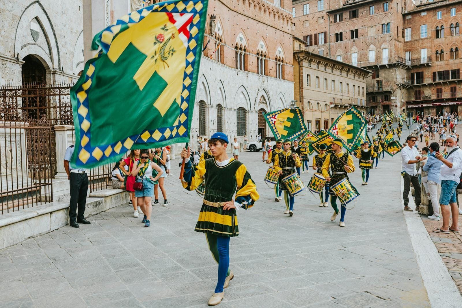 Des porte-drapeaux traditionnels lors d'un défilé haut en couleur sur la Piazza del Campo, à Sienne, mettant en valeur le riche patrimoine italien.