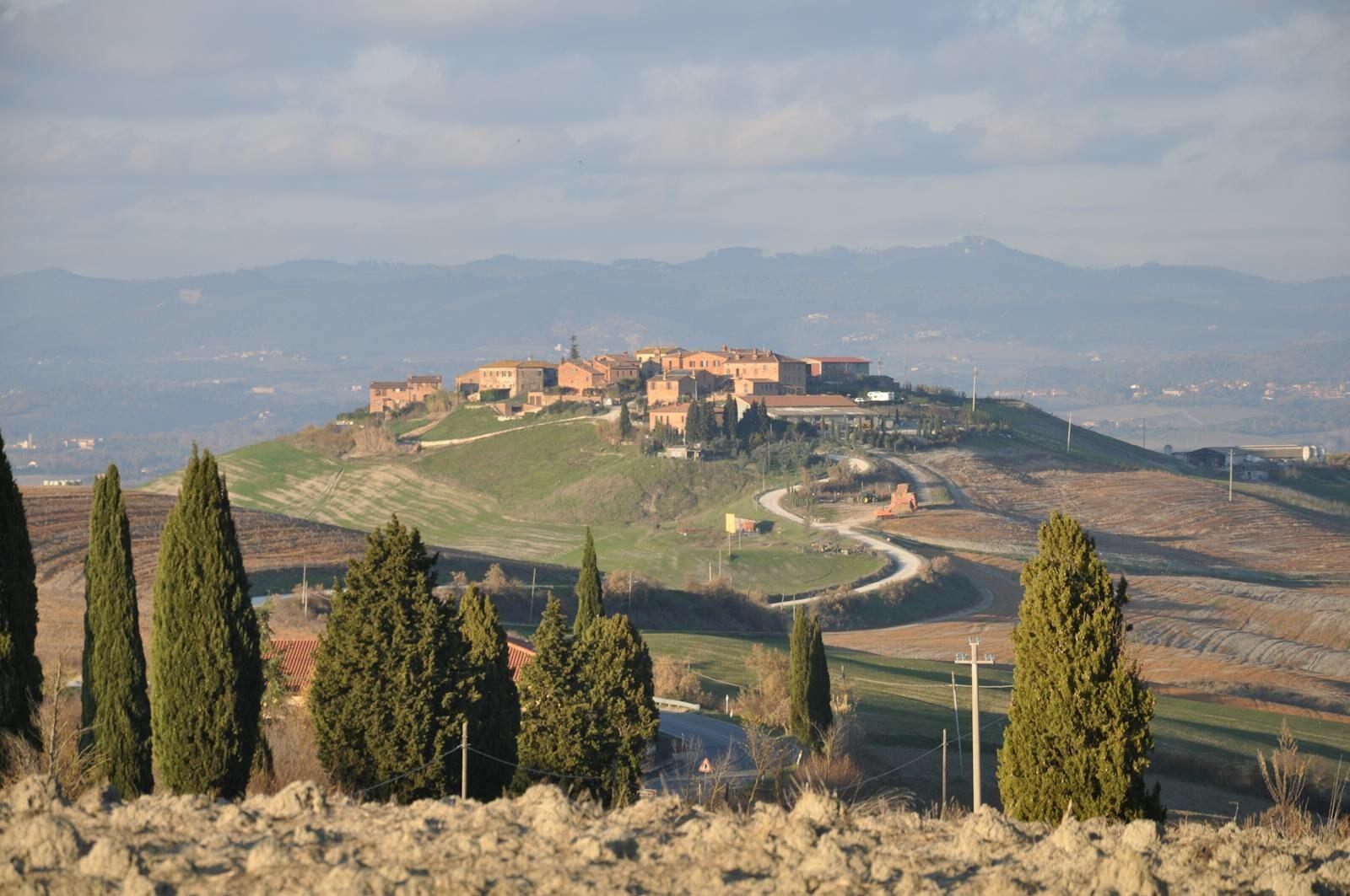 Vue panoramique sur Asciano, en Toscane, avec ses collines vallonnées et ses paysages pittoresques.