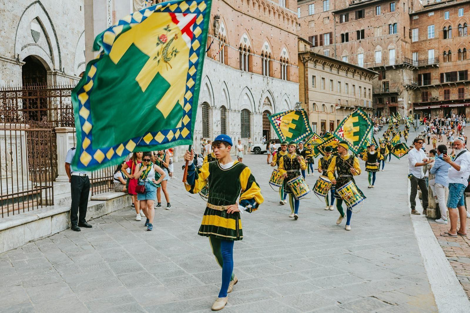 Des porte-drapeaux traditionnels lors d'un défilé haut en couleur sur la Piazza del Campo, à Sienne, mettant en valeur le riche patrimoine italien.